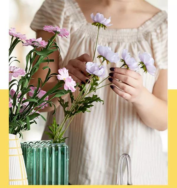 Woman arranging a floral display in a vase.